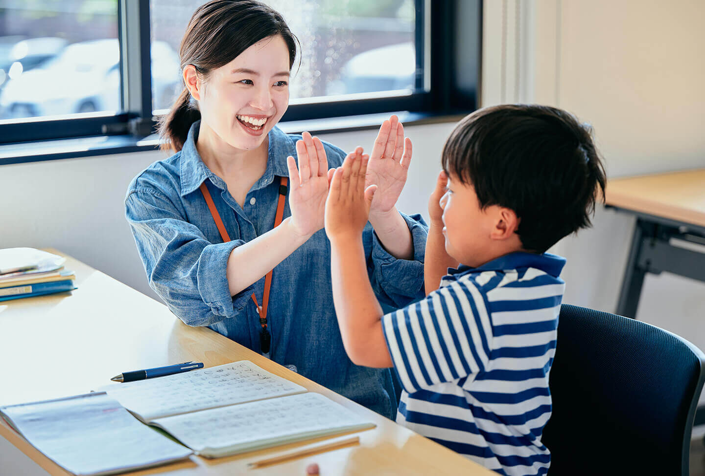 先生とハイタッチをする子ども